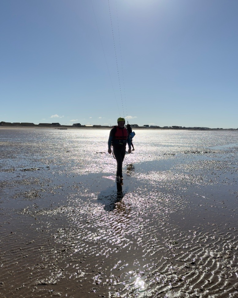 Nigel Marsh yellow helmet red buoyancy aid walking Hunstanton tidal flats North Norfolk UK kite lines overhead