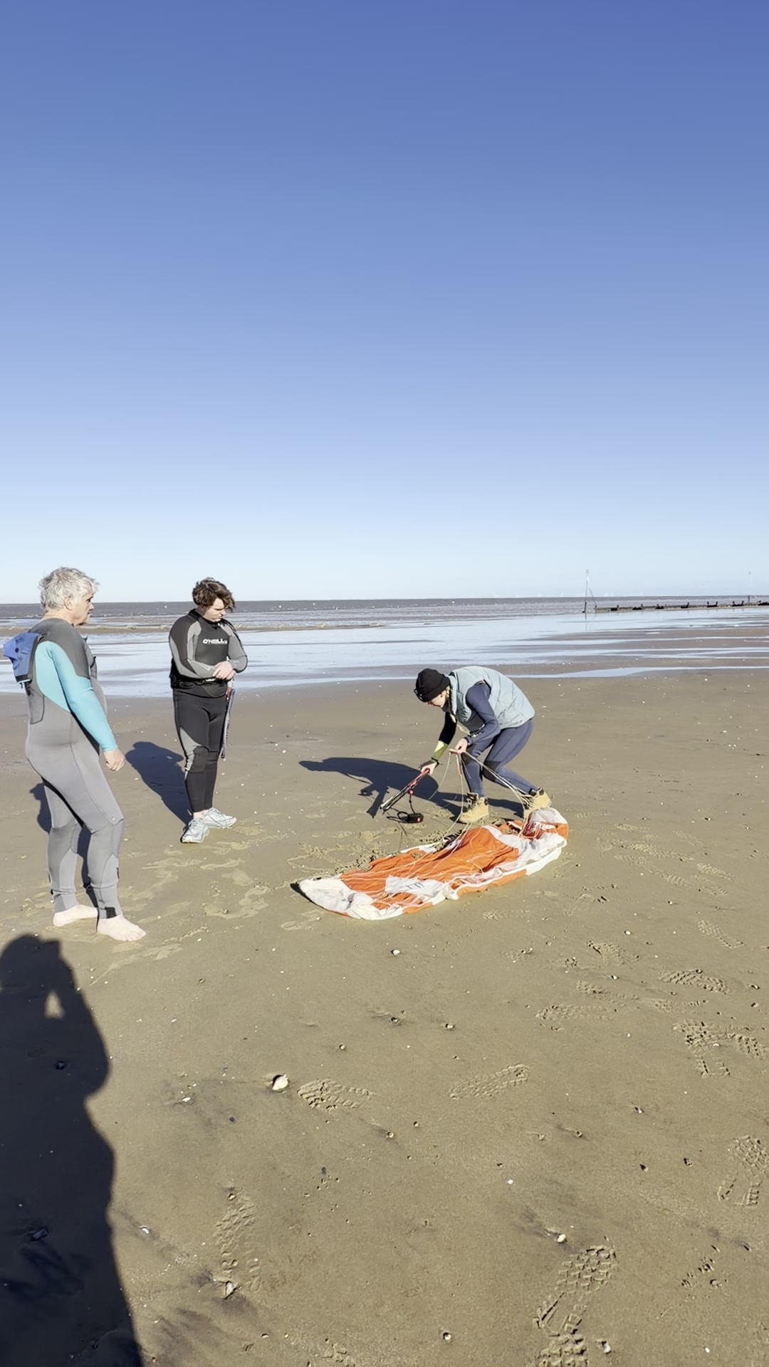 Orange trainer kite on sand setup Hunstanton beach kitesurf lesson North Norfolk UK